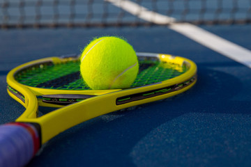Tennis ball on racket sitting by the net