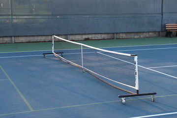 A view of a pickel ball net through a fence