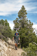 A young man hikes on a trail through California