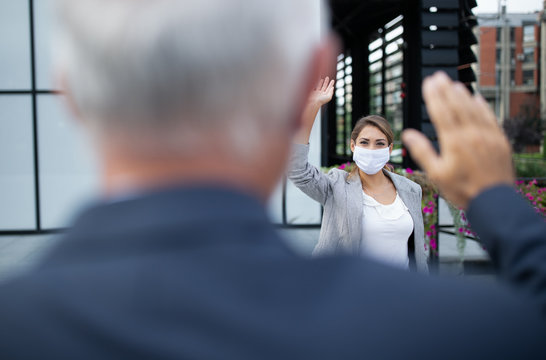 Business People Greeting By Waving Hands In Front Of Office