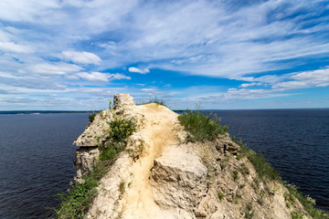 Rock with soil layers against blue sky.