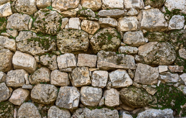 The ancient wall with rough stones.