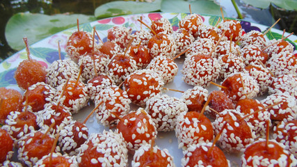 Small orange apples sprinkled with sugar and sesame seeds. Dessert. 