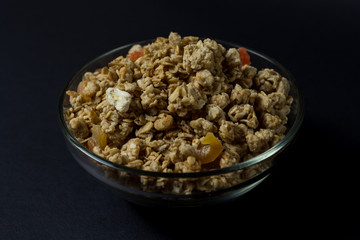 granola in a transparent plate with pieces of tropical fruits