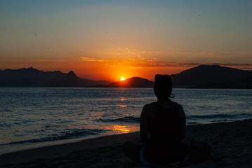 Fototapeta premium Silhouette of a woman on the beach at sunset.