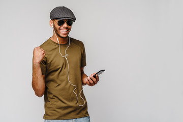 studio shot young african american man listening to music with earphones