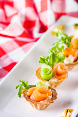 delicious snack tartlets on rustic wooden background