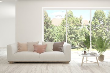 Fototapeta premium White living room with sofa and summer landscape in window. Scandinavian interior design. 3D illustration