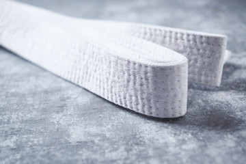 White karate belt on rustic wooden background. Close up. Copy space.  © Eugeniusz Dudziński