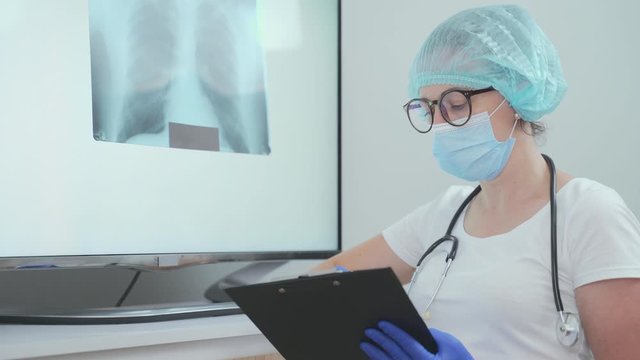 A young doctor doctor will erase a snapshot of the lungs. Diagnosis of pneumonia or tuberculosis. X-ray examination of the patient. Prevention, lung cancer, pneumonia and tuberculosis