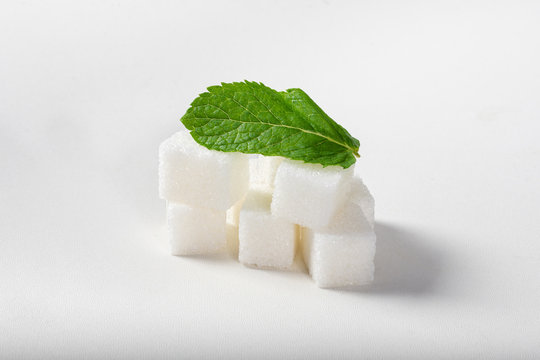 Refined sugar with mint on a white background. Set of mint and sugar.