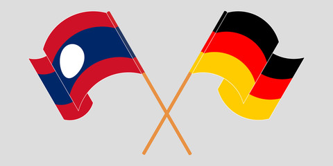 Crossed and waving flags of Laos and Germany