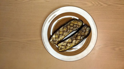 Two fried eggplants on transparent plates top view 