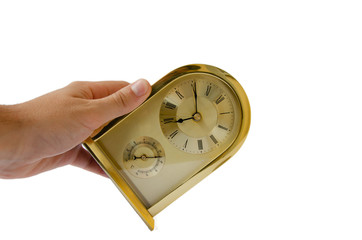 Golden alarm clock hand. A man holds a gilded home watch. Golden clock white background.