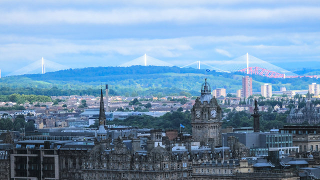 Aerial view of old town Edinburgh skyline with the Balmoral clock tower on a clear day. The Forth Road bridge and Forth Bridge are in the background
