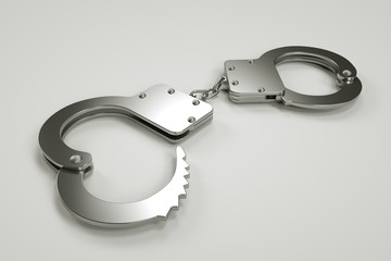 Metal handcuffs lie on a gray background, arrest and detention, violation of the law