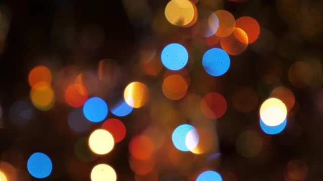 Beautiful blurred glowing blinking Christmas garland on the New Year tree. Holiday festive dynamic background