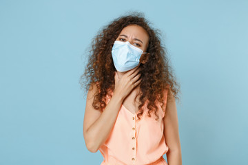 Sick young african american woman girl in pastel clothes sterile face mask isolated on blue...