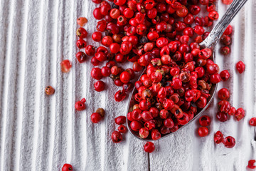 pink peppercorns on white wooden rustic background