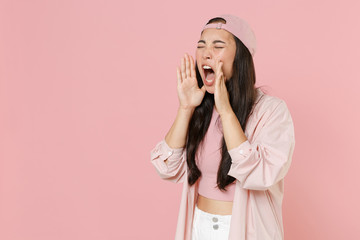 Nervous young asian woman girl in casual clothes cap posing isolated on pastel pink background. People lifestyle concept. Mock up copy space. Keeping eyes closed scream with hands gesture near mouth.