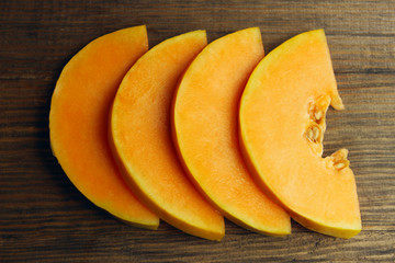 Yellow melon sliced on brown wooden background. Food background. Melon on the table.