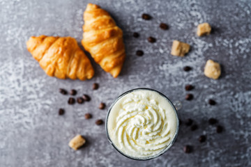 Coffee with whipped cream in a glass with coffee beans