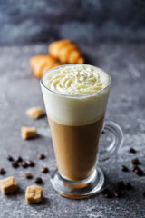Coffee with whipped cream in a glass with coffee beans