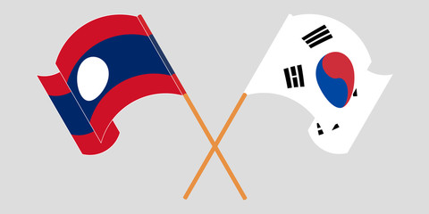 Crossed and waving flags of Laos and South Korea