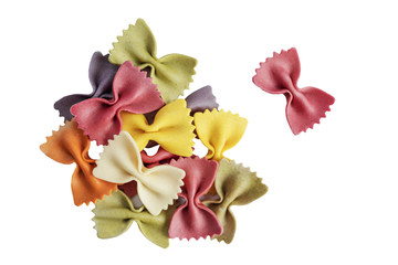 Raw colorful farfalle pasta. Pieces of traditional Italian farfalle pasta isolated on a white bachground. Italian Cuisine. Dry bow tie noodles. Uncooked dried farfalle. Butterfly. Top view. Copy space