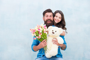 Fototapeta na wymiar Joy that never ends. Happy family celebrate spring holiday. Happy father and daughter hold toy and flowers. Gift shop. Joy and pleasure. Special occasion. Enjoying holidays together