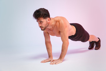 Full length portrait young fitness sporty strong guy bare-chested muscular sportsman isolated on white background studio portrait. Workout sport motivation lifestyle concept. Doing push-ups exercises.