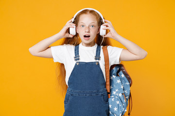 Young redhead school teen kid girl 12-13 years old in white t-shirt blue uniform backpack listen...
