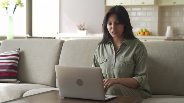 Smiling young indian woman video calling for remote job interview using laptop webcam conference work at home office. Happy lady talking by virtual chat meeting dating online using computer videocall.