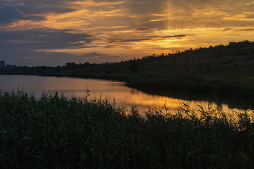 Sunrise or sunset over small lake. Contrast sunlight