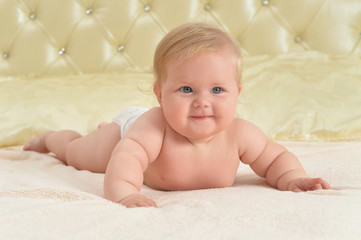 Cute little happy baby girl on bed