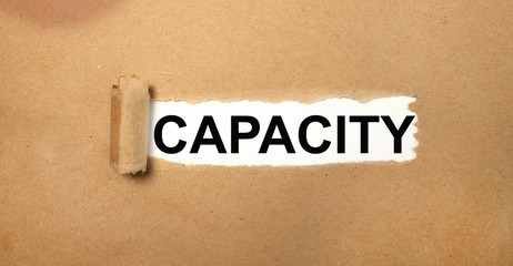 capacity. text on white paper written in black letters on torn paper