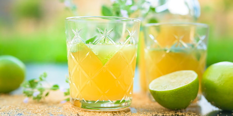 Beautiful Cocktail mojito in front of blurred  natural green background