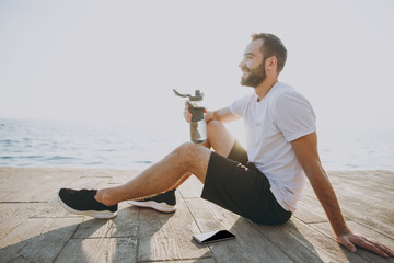 Full lenght portrait side view of smiling young bearded fitness athletic man guy 20s in white...