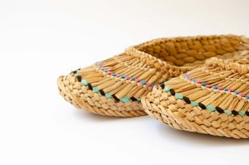 Straw slippers white background. Wicker slippers. Ancient home shoes white background.