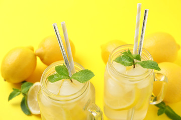 Natural freshly made lemonade with mint on yellow background, closeup. Summer refreshing drink