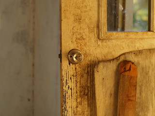 A wooden door with a lock in an abandoned house. Close up.