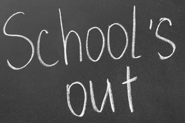 Fototapeta premium Words School's Out on blackboard. Summer holidays