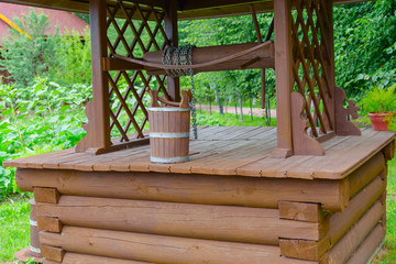 wooden well and bucket in the country side