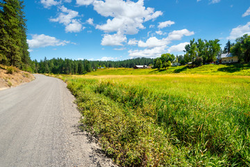A gravel road past hillside homes in the rural Colbert area near Spokane, Washington, USA