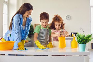 Family cleaning room together and having fun. Kids helping parent to do domestic chores at home