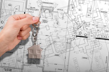 Drawing architecture or construction blueprint and hand with a key