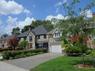 suburban street of two story detached houses with large front yards