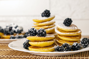 Pancakes served with black currant and blackberry. Dessert and breakfast concept