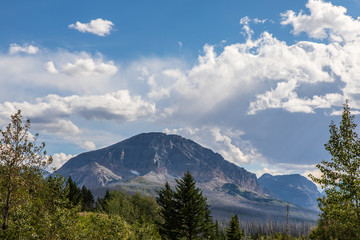 Clouds over a mountain with trees in foreground