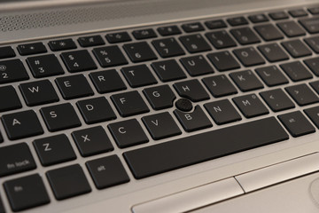 Laptop keyboard close-up with bokeh black keys with silver chassis